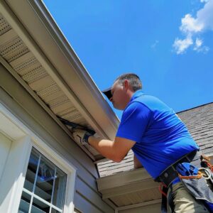 Professional installing gutter guards on a Kansas City home, highlighting home protection and maintenance